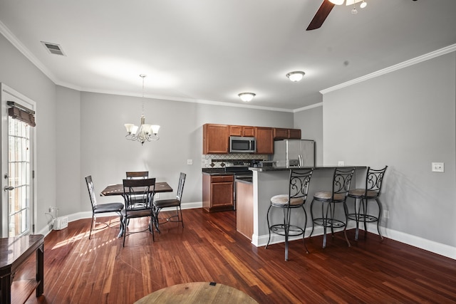 kitchen with decorative backsplash, ornamental molding, stainless steel appliances, decorative light fixtures, and dark hardwood / wood-style floors