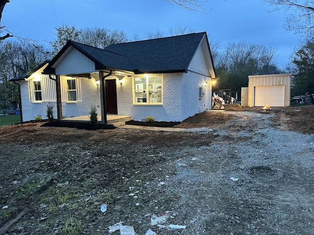 view of front of home featuring a garage and an outbuilding