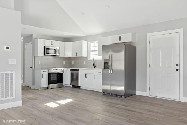 kitchen with light hardwood / wood-style flooring, white cabinets, stainless steel appliances, and sink