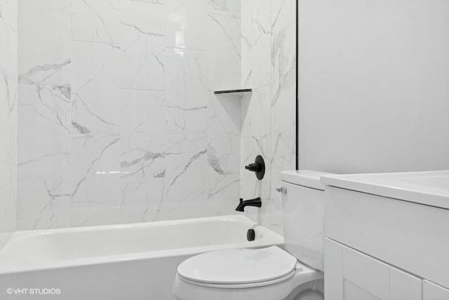 full bathroom featuring tiled shower / bath combo, toilet, and vanity