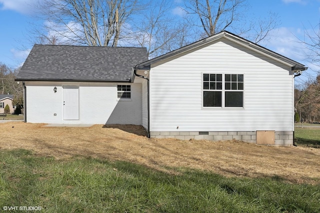 rear view of property featuring a lawn