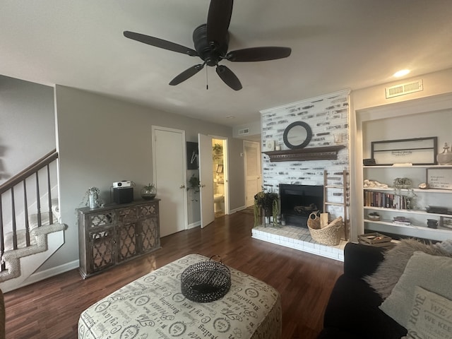 living room featuring a fireplace, dark hardwood / wood-style floors, and ceiling fan