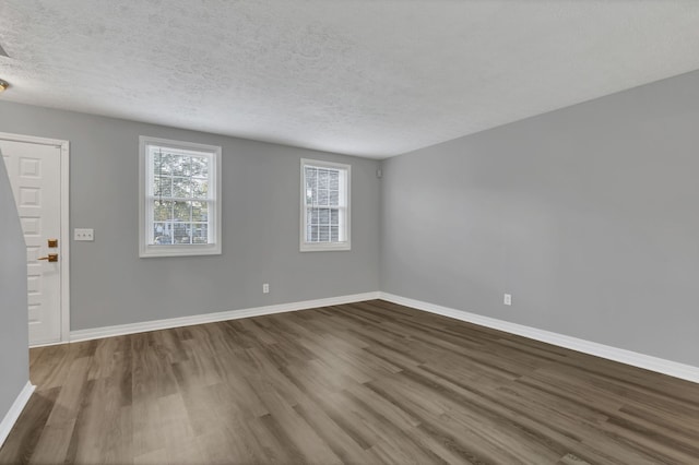 unfurnished room with wood-type flooring and a textured ceiling