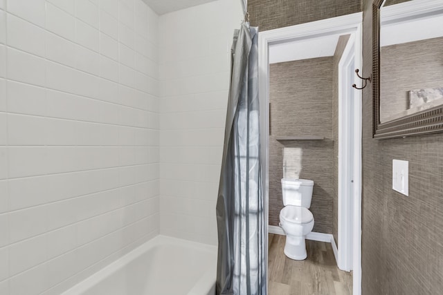 bathroom featuring toilet, wood-type flooring, and shower / tub combo