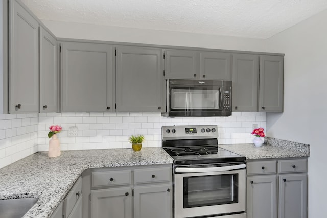 kitchen with backsplash, gray cabinets, and stainless steel electric range