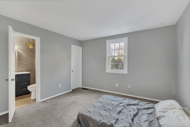 carpeted bedroom featuring ensuite bath