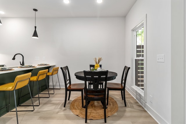 dining area with light hardwood / wood-style floors and sink