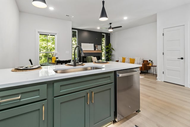 kitchen featuring dishwasher, light hardwood / wood-style flooring, green cabinetry, and sink