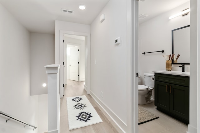 bathroom featuring toilet, vanity, and hardwood / wood-style flooring