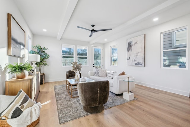 living room with light wood-type flooring, ceiling fan, and beam ceiling