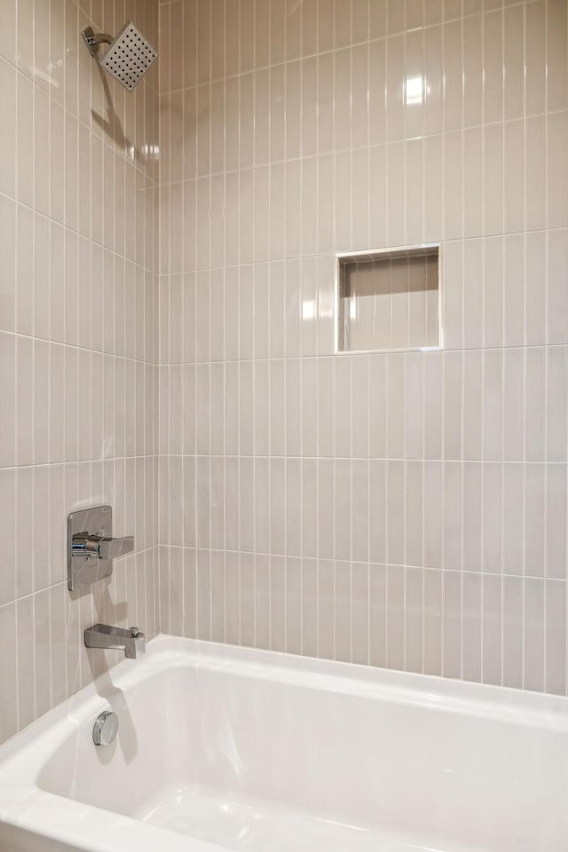 bathroom with tiled shower / bath combo