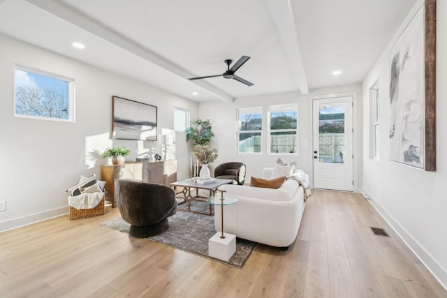 living room with light wood-type flooring, ceiling fan, and beamed ceiling