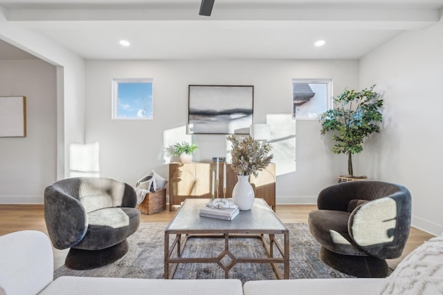 living room with light hardwood / wood-style floors and beamed ceiling