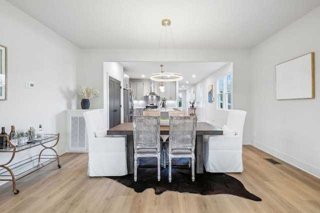 dining area featuring a chandelier and light wood-type flooring