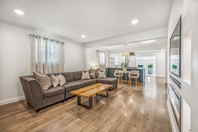 living room featuring a wealth of natural light, sink, french doors, and hardwood / wood-style flooring