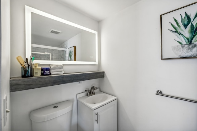 bathroom featuring vanity, toilet, and a shower with door