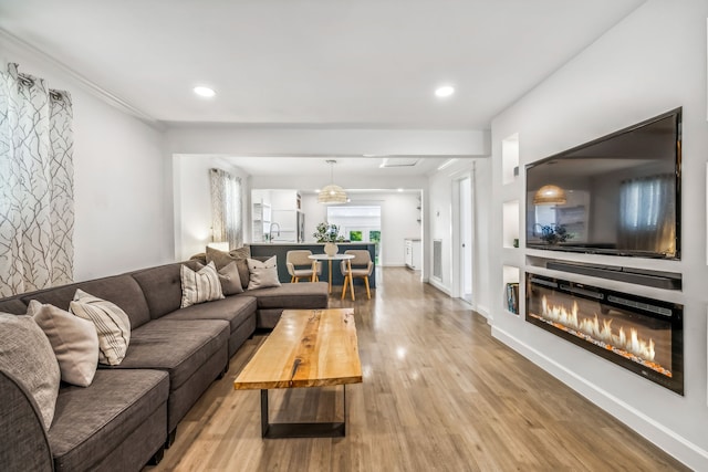 living room with light hardwood / wood-style floors and sink