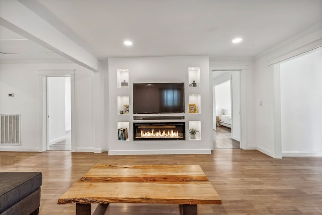 living room featuring built in shelves and hardwood / wood-style flooring