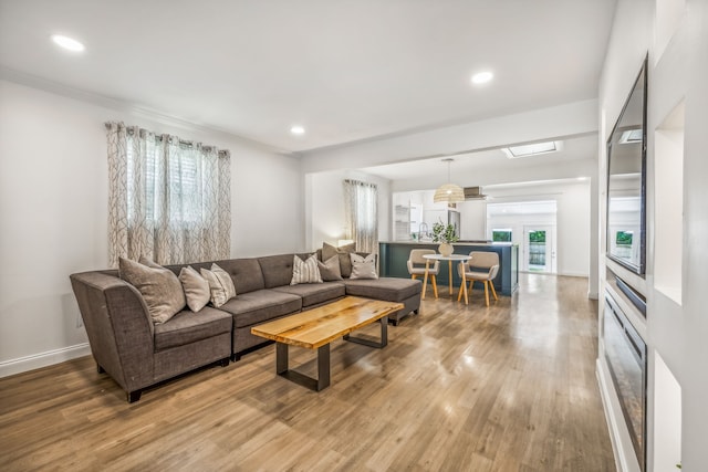 living room featuring french doors, hardwood / wood-style flooring, plenty of natural light, and sink