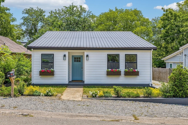 bungalow with fence and metal roof