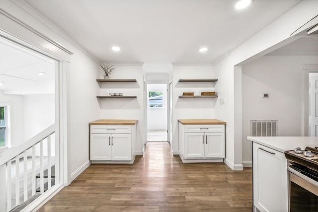 kitchen with wood counters, white cabinets, and a healthy amount of sunlight