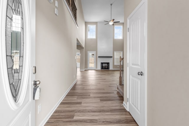 hallway with light wood-type flooring and a high ceiling