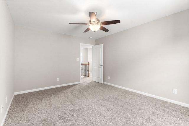 carpeted spare room with ceiling fan