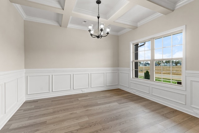 empty room featuring beamed ceiling, ornamental molding, light wood-type flooring, and a notable chandelier