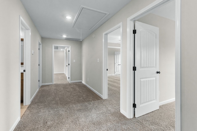 hallway featuring light colored carpet