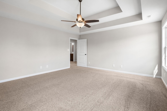 spare room featuring carpet, a tray ceiling, plenty of natural light, and ceiling fan