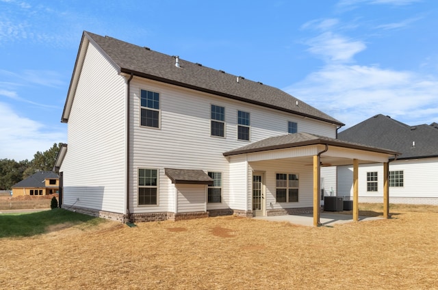 rear view of house with a yard, a patio, and central AC