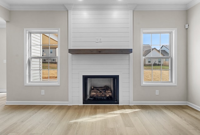 unfurnished living room with a large fireplace, light hardwood / wood-style flooring, and ornamental molding