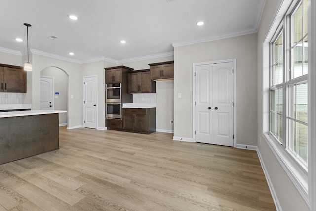 kitchen featuring dark brown cabinets, light hardwood / wood-style flooring, and hanging light fixtures