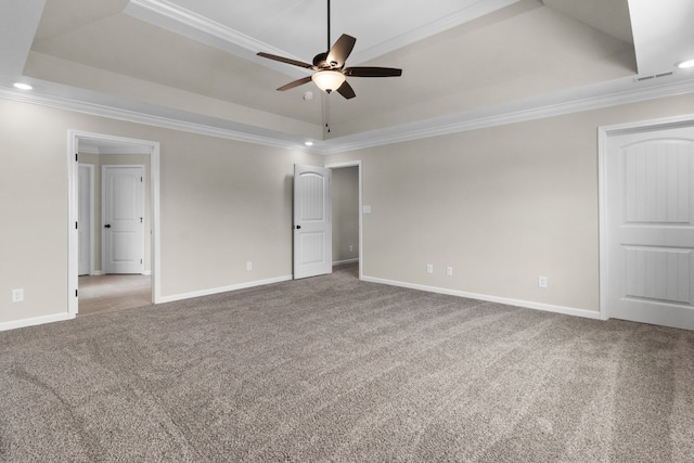 carpeted spare room with ceiling fan, crown molding, and a tray ceiling