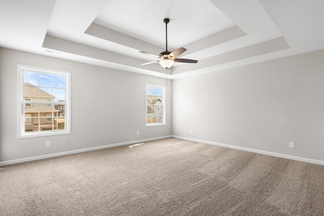 empty room with a tray ceiling and carpet