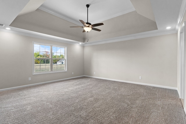 unfurnished room featuring a raised ceiling, ceiling fan, carpet flooring, and ornamental molding