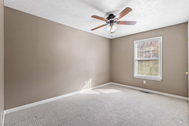 unfurnished room with ceiling fan, carpet floors, and a textured ceiling