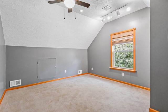 additional living space with carpet flooring, a textured ceiling, ceiling fan, and lofted ceiling