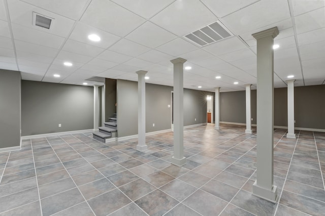 basement featuring tile patterned flooring and a drop ceiling