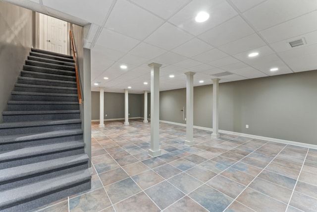 basement with a paneled ceiling and tile patterned floors