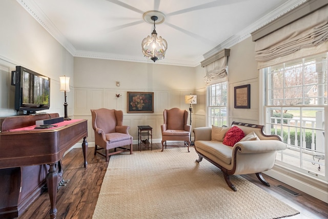 sitting room featuring crown molding, plenty of natural light, and dark wood-type flooring