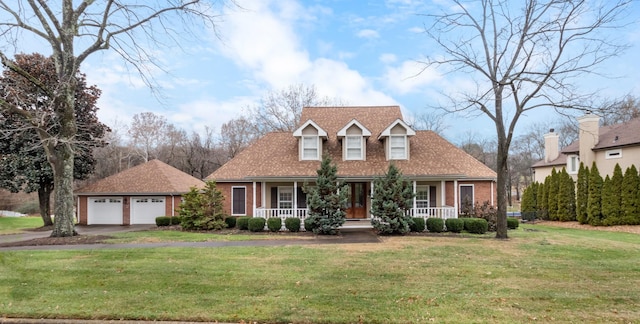 cape cod home featuring a porch, a garage, a front lawn, and an outdoor structure