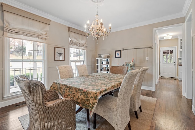 dining area featuring a chandelier, dark hardwood / wood-style floors, and ornamental molding