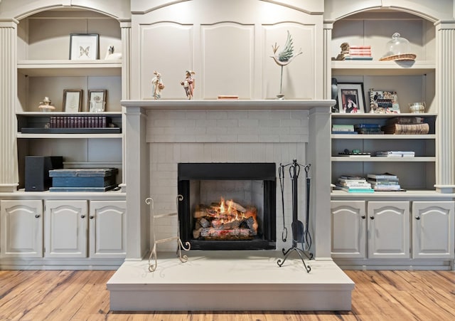 details with hardwood / wood-style floors and a brick fireplace