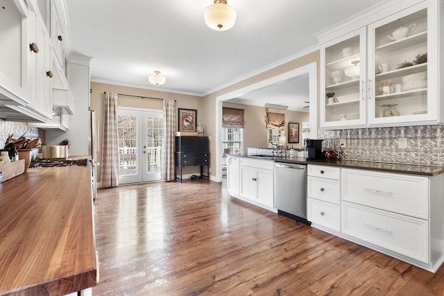 kitchen with white cabinetry, french doors, stainless steel dishwasher, backsplash, and light wood-type flooring