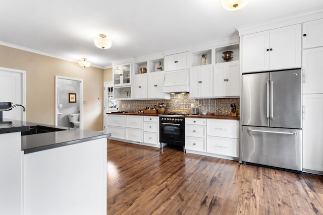 kitchen featuring white cabinets, dark hardwood / wood-style floors, stainless steel refrigerator, and black range