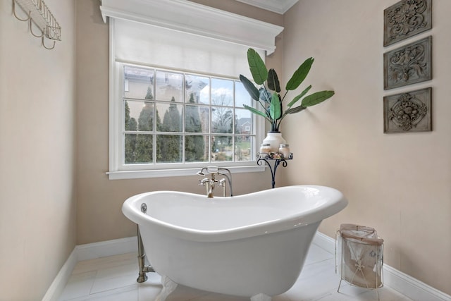 bathroom featuring a tub to relax in, tile patterned flooring, and ornamental molding