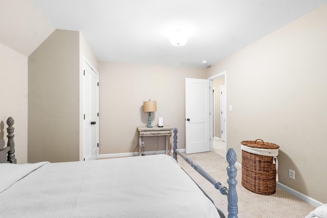 bedroom featuring light colored carpet and lofted ceiling