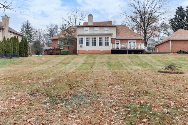 back of house featuring a lawn and a deck