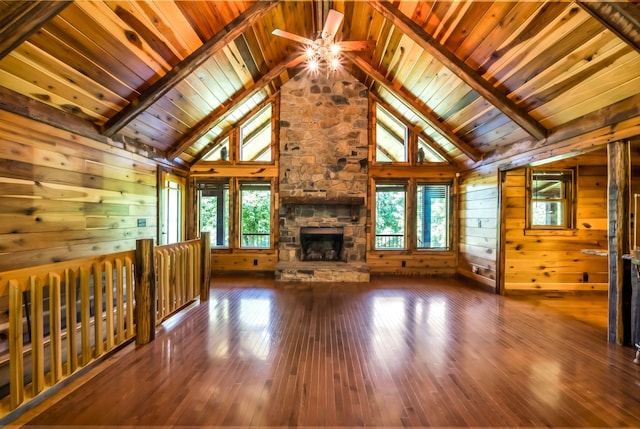 unfurnished living room with hardwood / wood-style flooring, plenty of natural light, and wooden walls